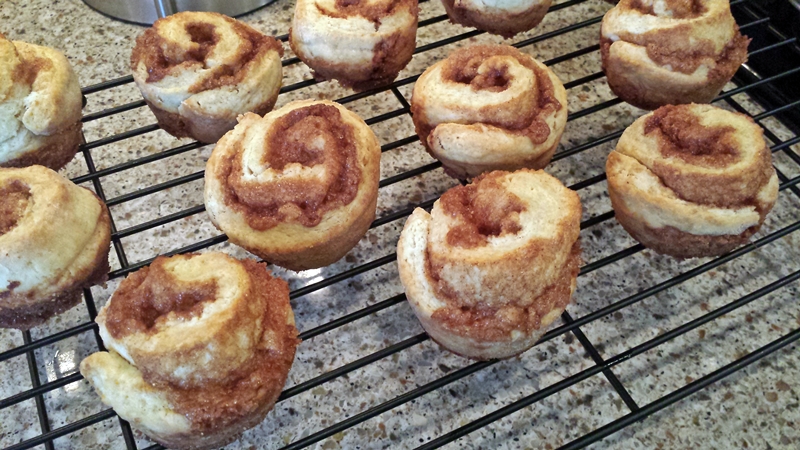 Several cinnamon roll muffins cooling on a rack